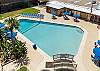 Large, heated pool with loungers, chairs, and umbrellas