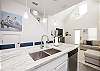 Open concept kitchen space with breakfast bar, beautiful counter tops and new lighting 