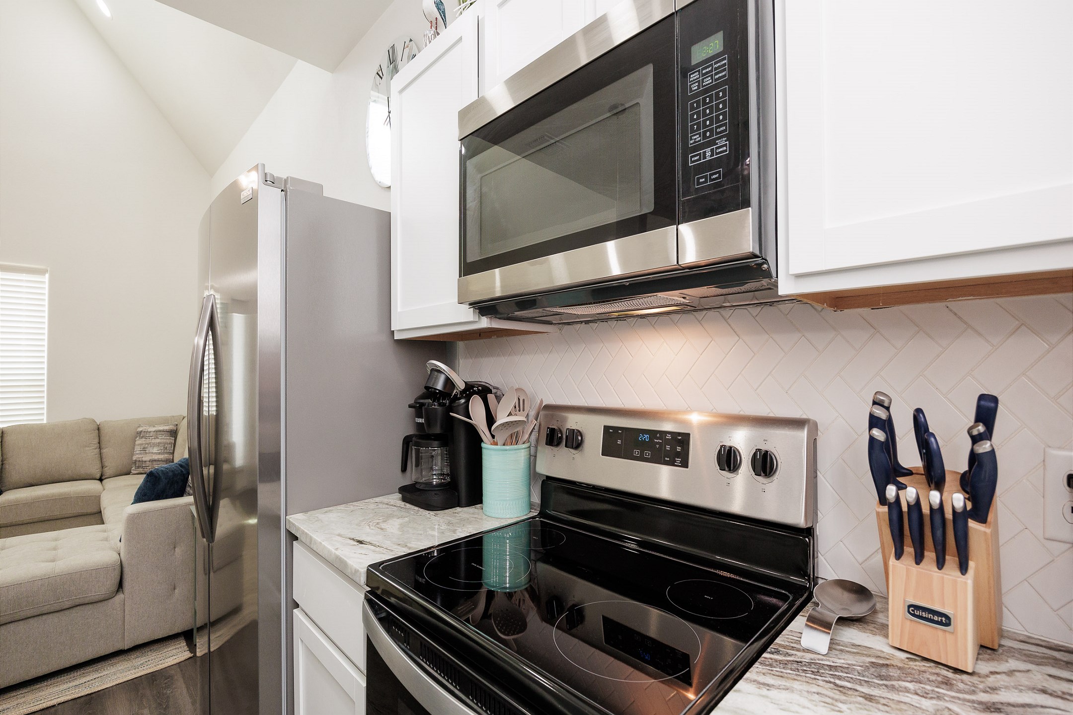 Well-equipped kitchen with stainless steel appliances, beautiful counter tops, and cabinets