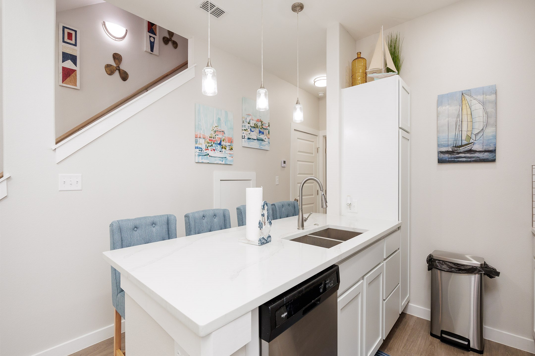 Open concept kitchen space with breakfast bar, beautiful counter tops, and new lighting 