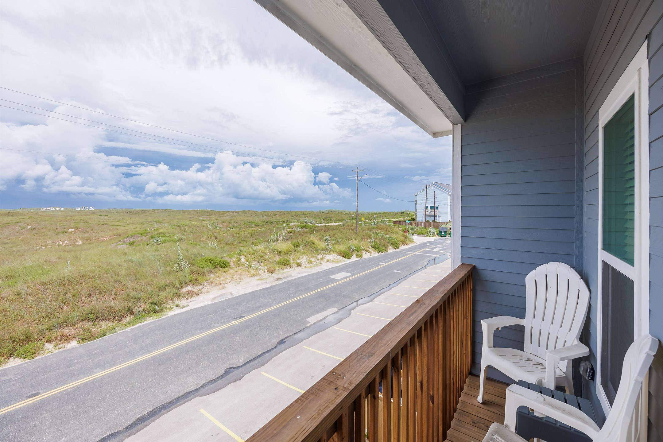 Private balcony off the second bedroom with chairs and coastal views 