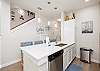 Open concept kitchen space with breakfast bar, beautiful counter tops and new lighting 