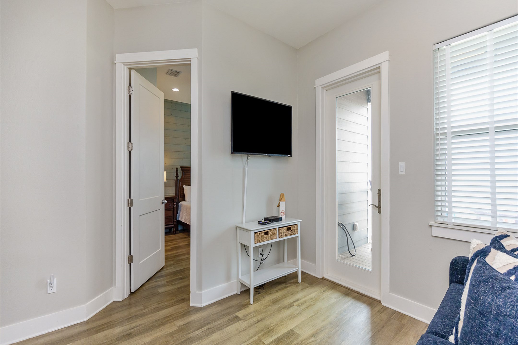 Second living area on the third floor has a cozy sofa, balcony access, and flat screen TV