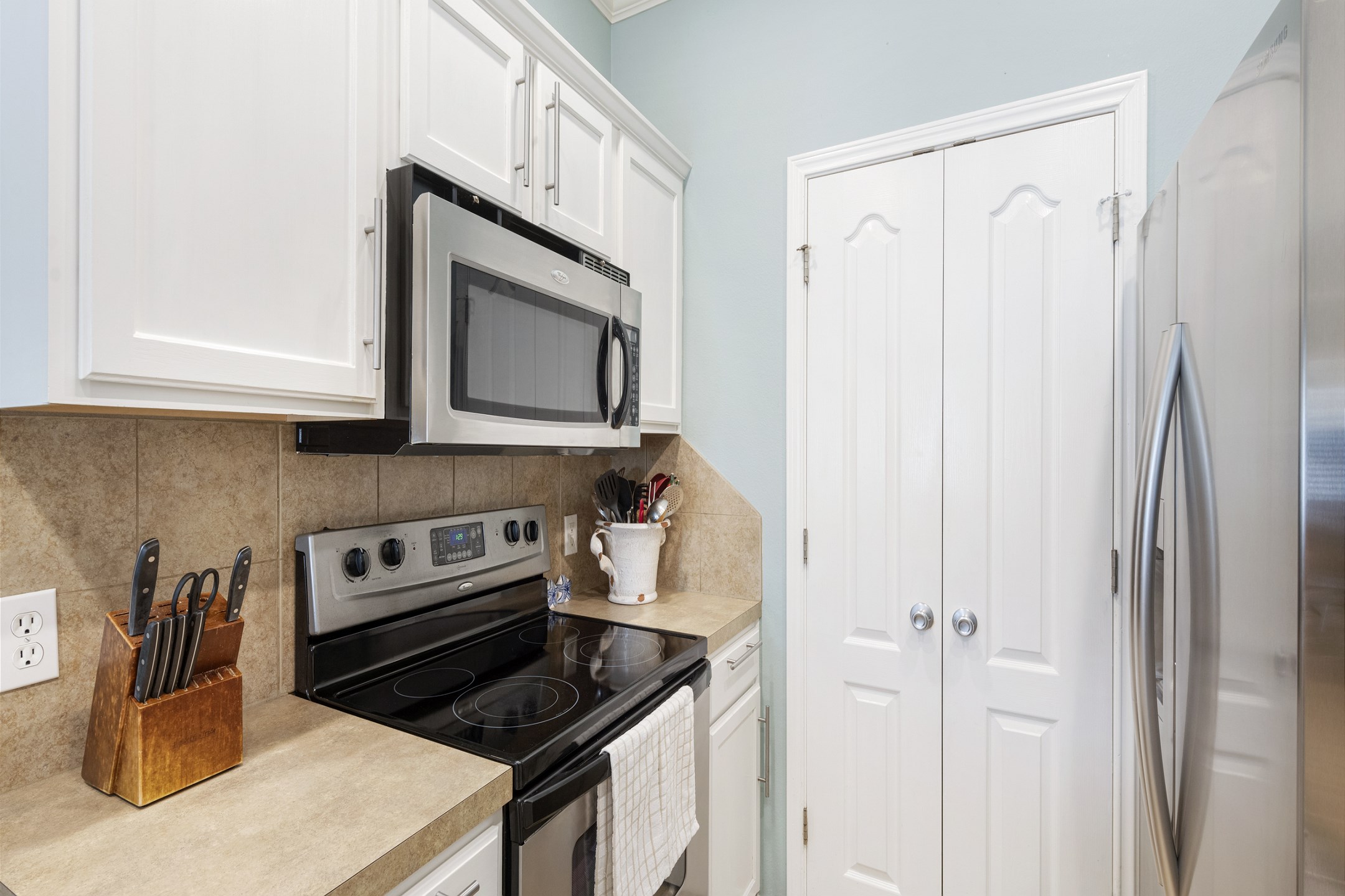 Fully equipped kitchen with coffee maker, toaster, cookware, dinnerware, and other kitchen essentials provided