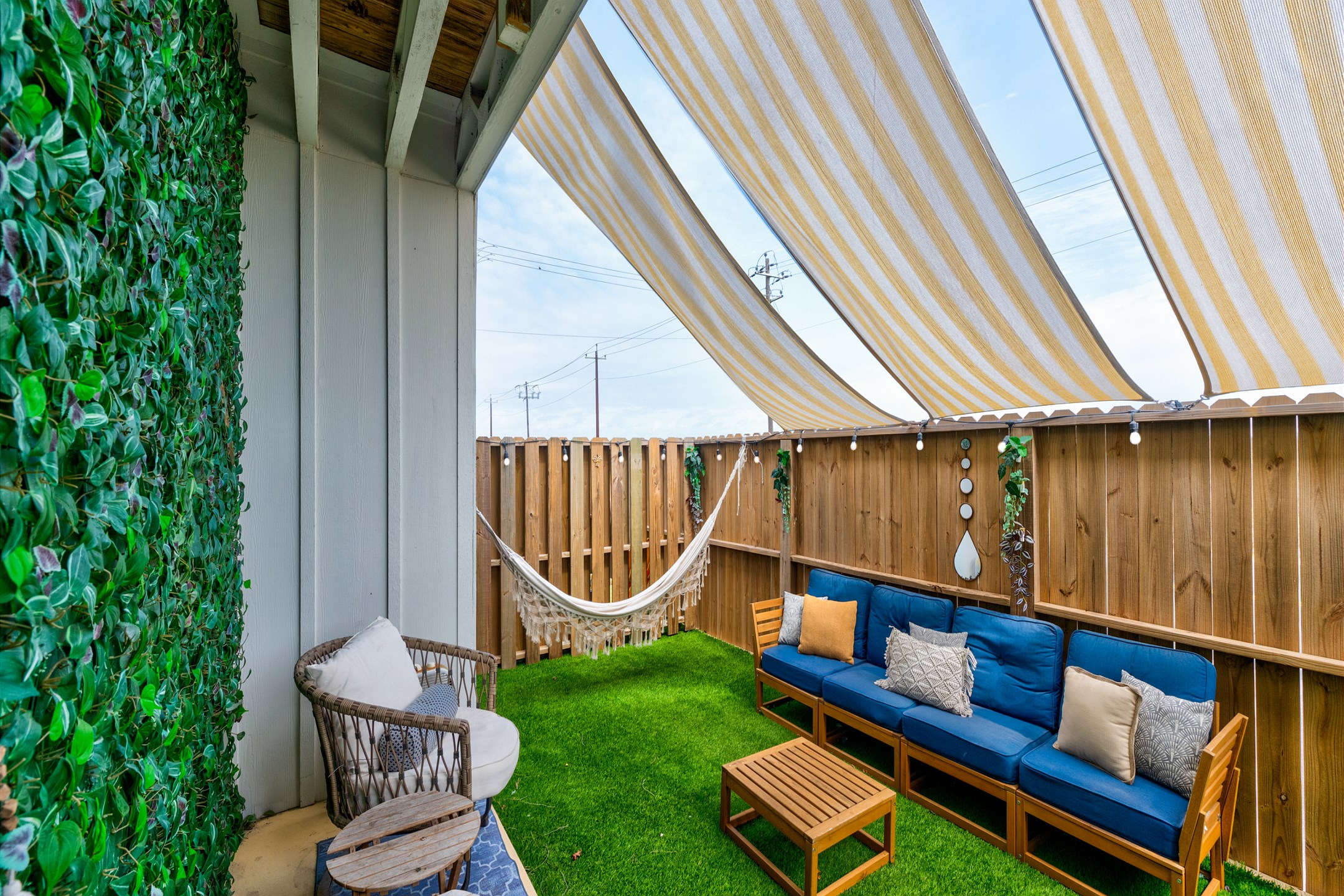 Private, fenced in patio off the master bedroom with chairs, turf grass, hammock and access through the back gate 