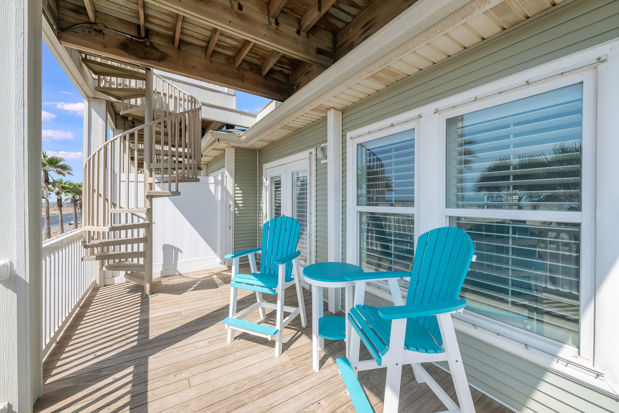 Covered balcony with seating off the 2nd floor bedroom, ideal for afternoon drinks or evening chats