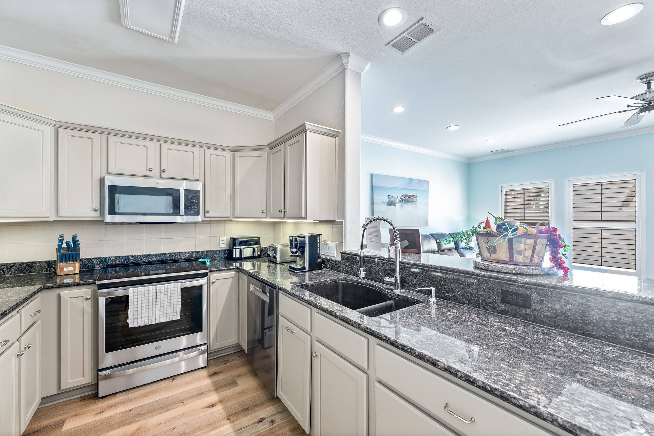 Spacious kitchen includes granite countertops, full-size fridge, stove, microwave, and dishwasher