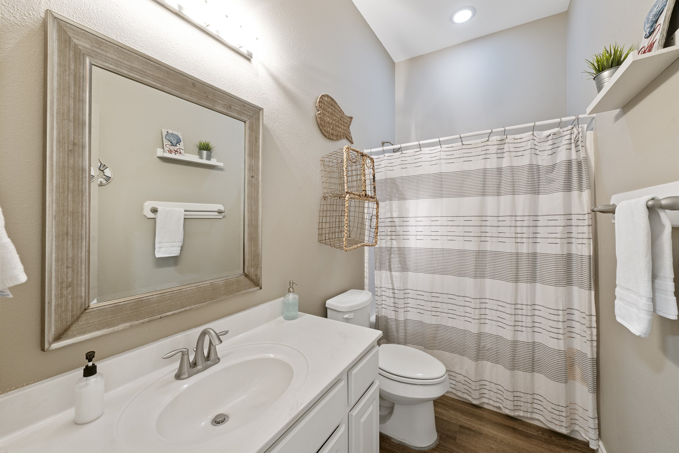 Sunny vibes meet splash time! This breezy bath features a tub/shower combo and just the right touch of vacation chill