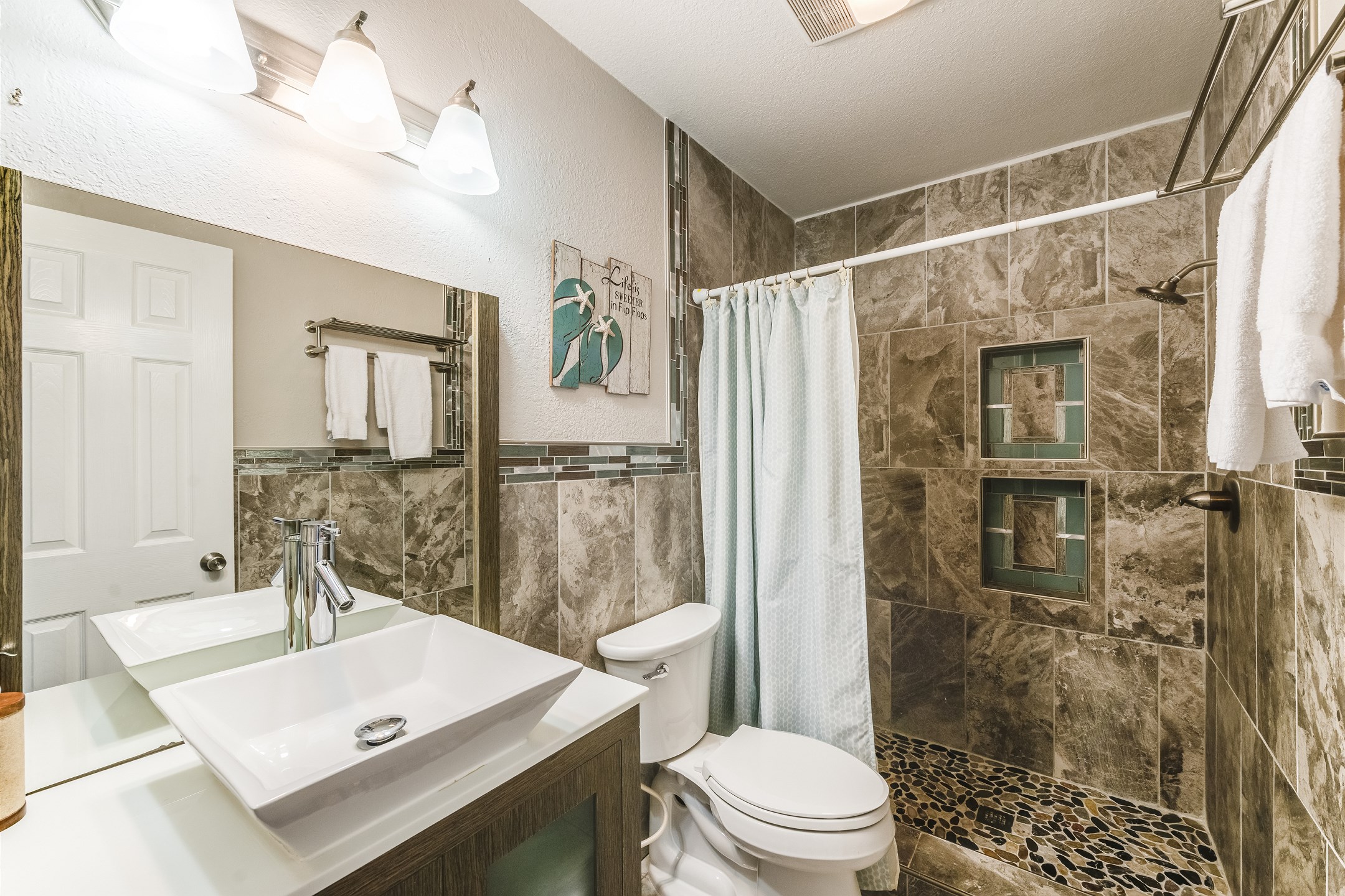 Bright and airy guest bath featuring a walk-in shower perfect for your vacation needs