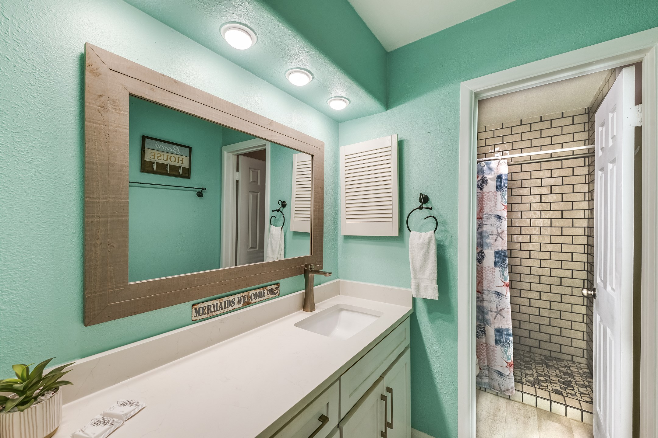 Mermaids will love the large mirror and great lighting in this bathroom