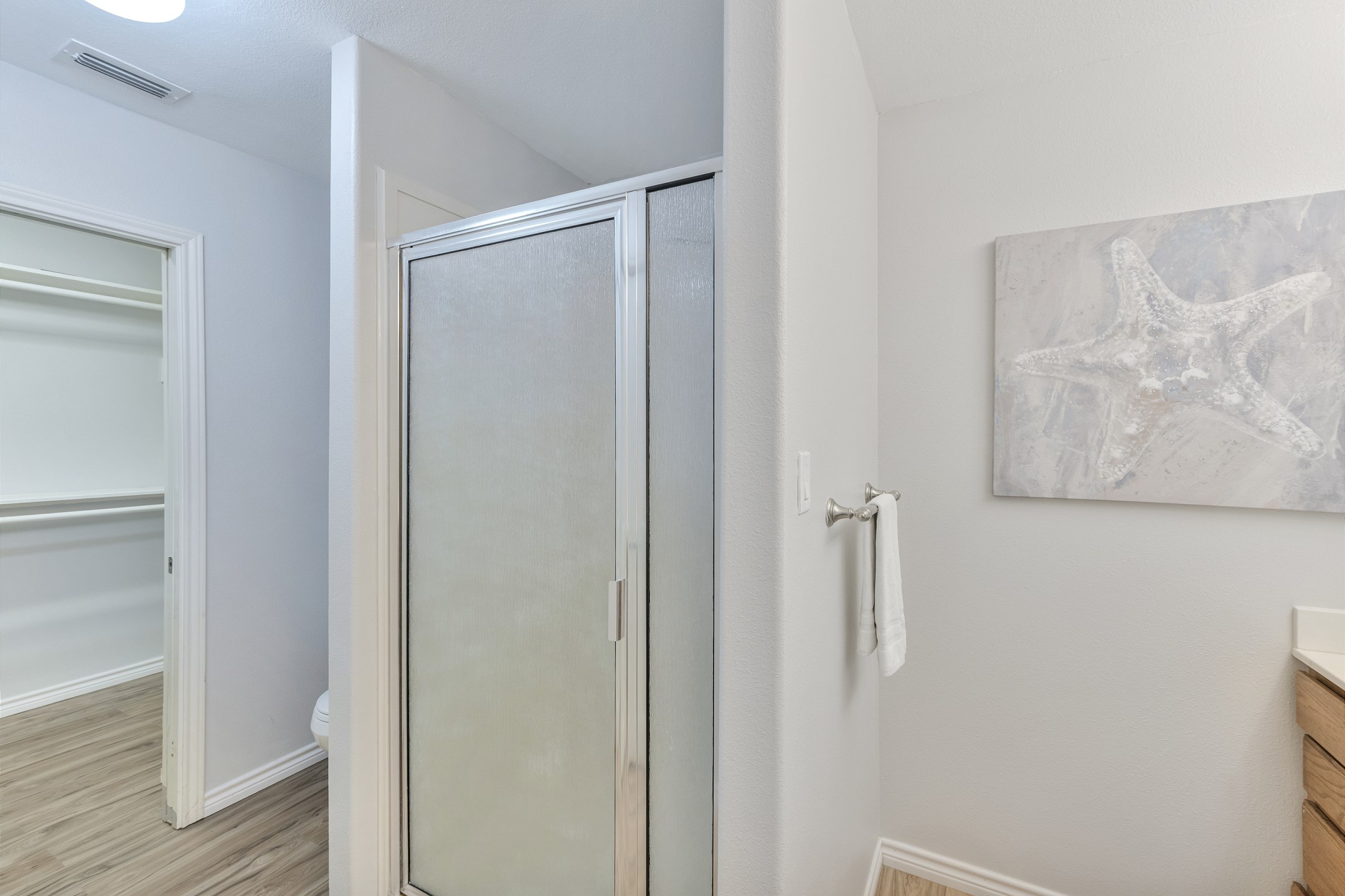 Primary bathroom with a seating area, walk in shower and walk in closet