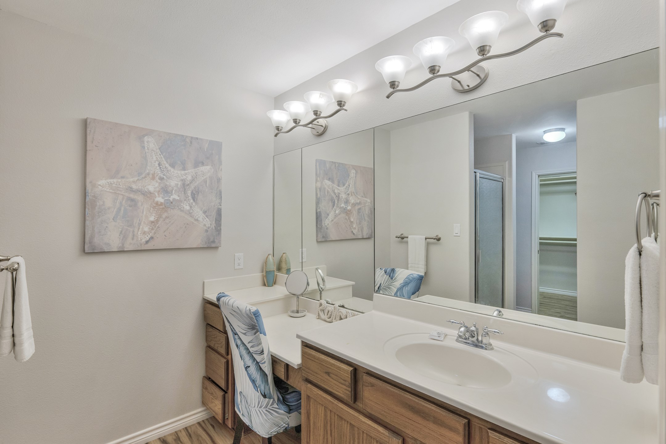 Primary bathroom with a seating area, walk in shower and walk in closet