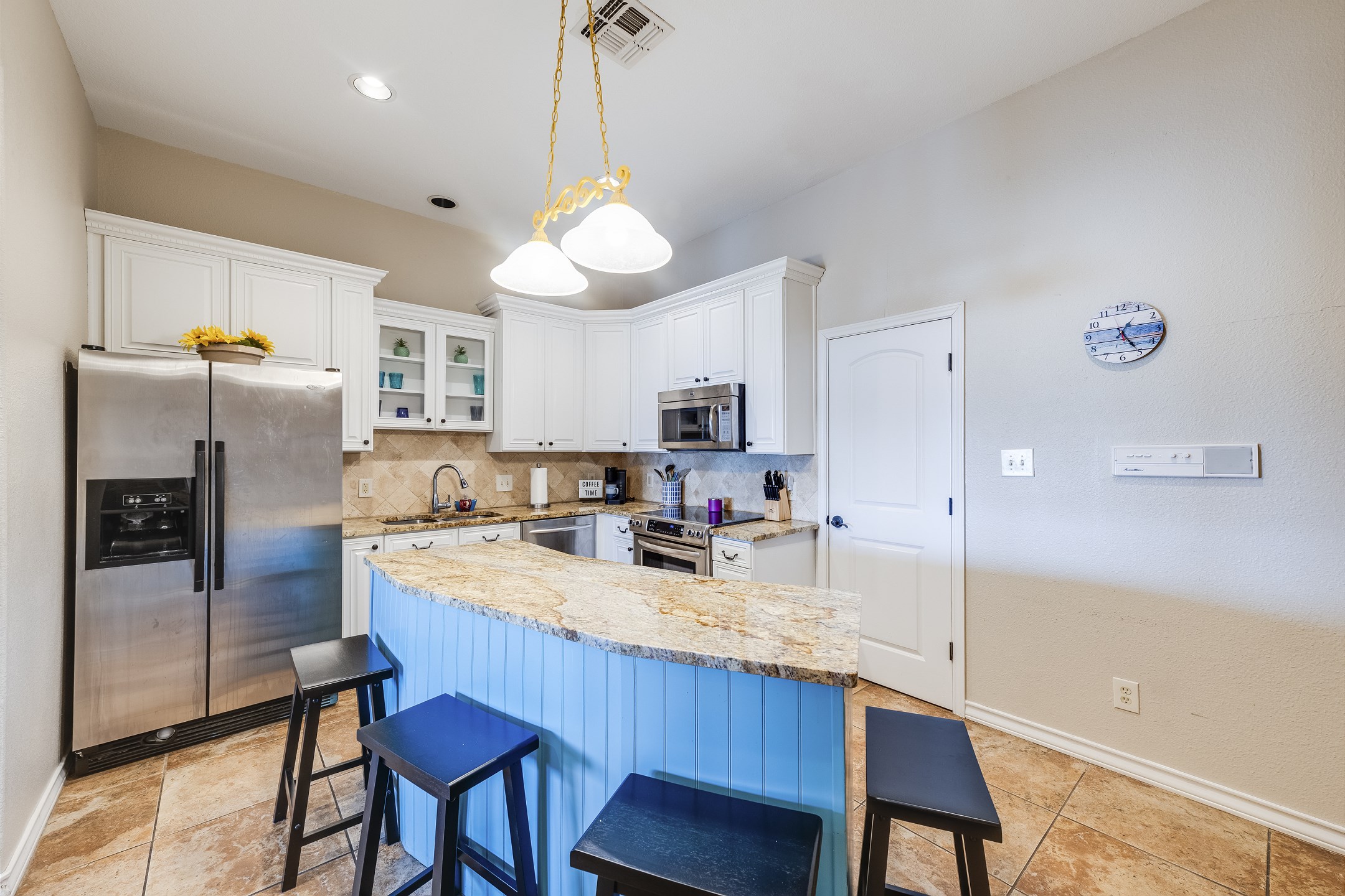 Fully equipped kitchen with stainless steel appliances and seating for four