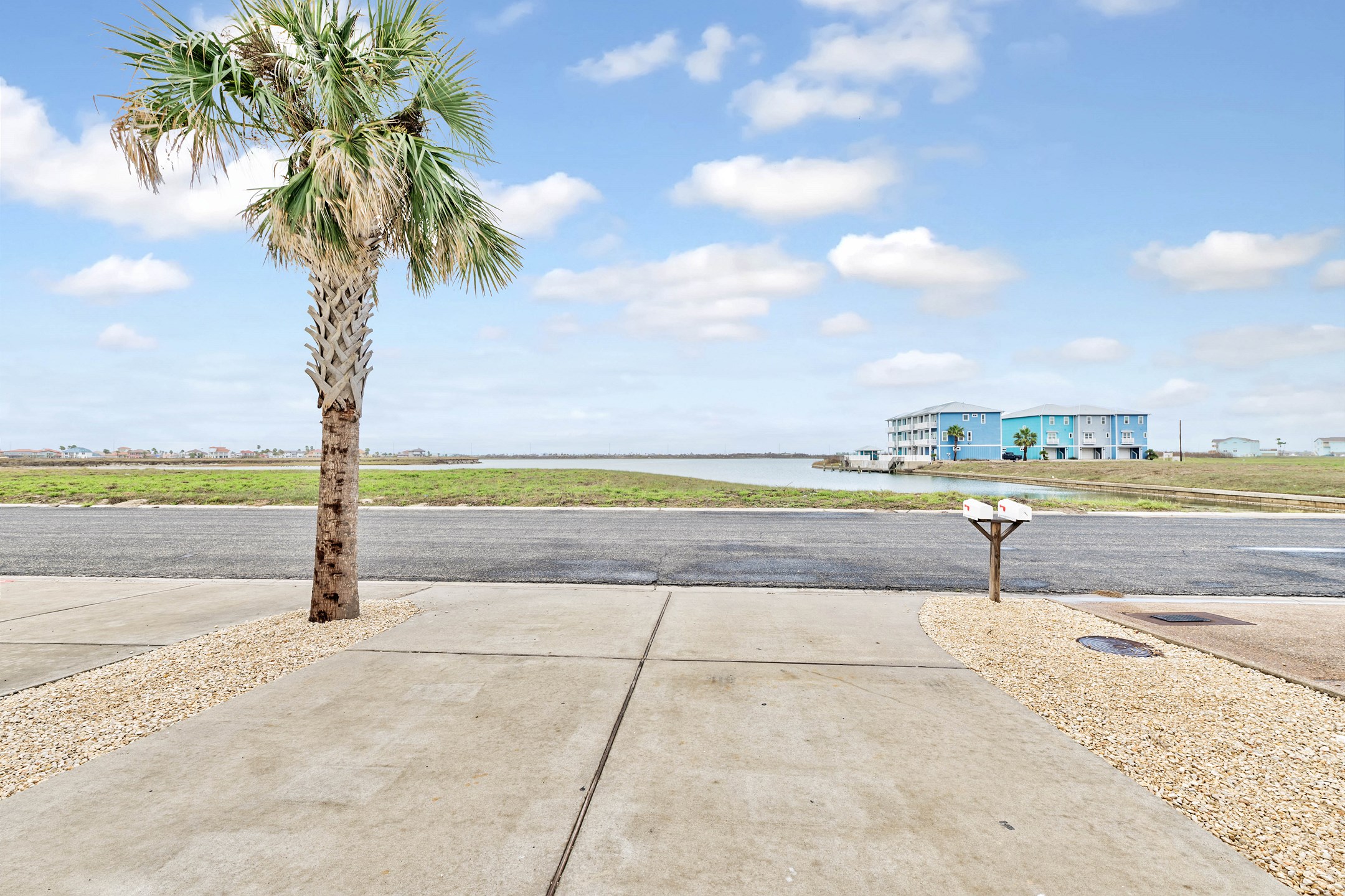 Front entrance of property with driveway parking and lovely views of water across the street