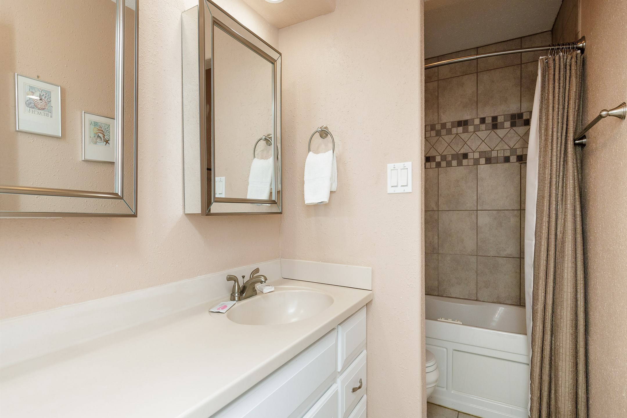 Guest bathroom on the second floor with separate sink area and tub / shower combo