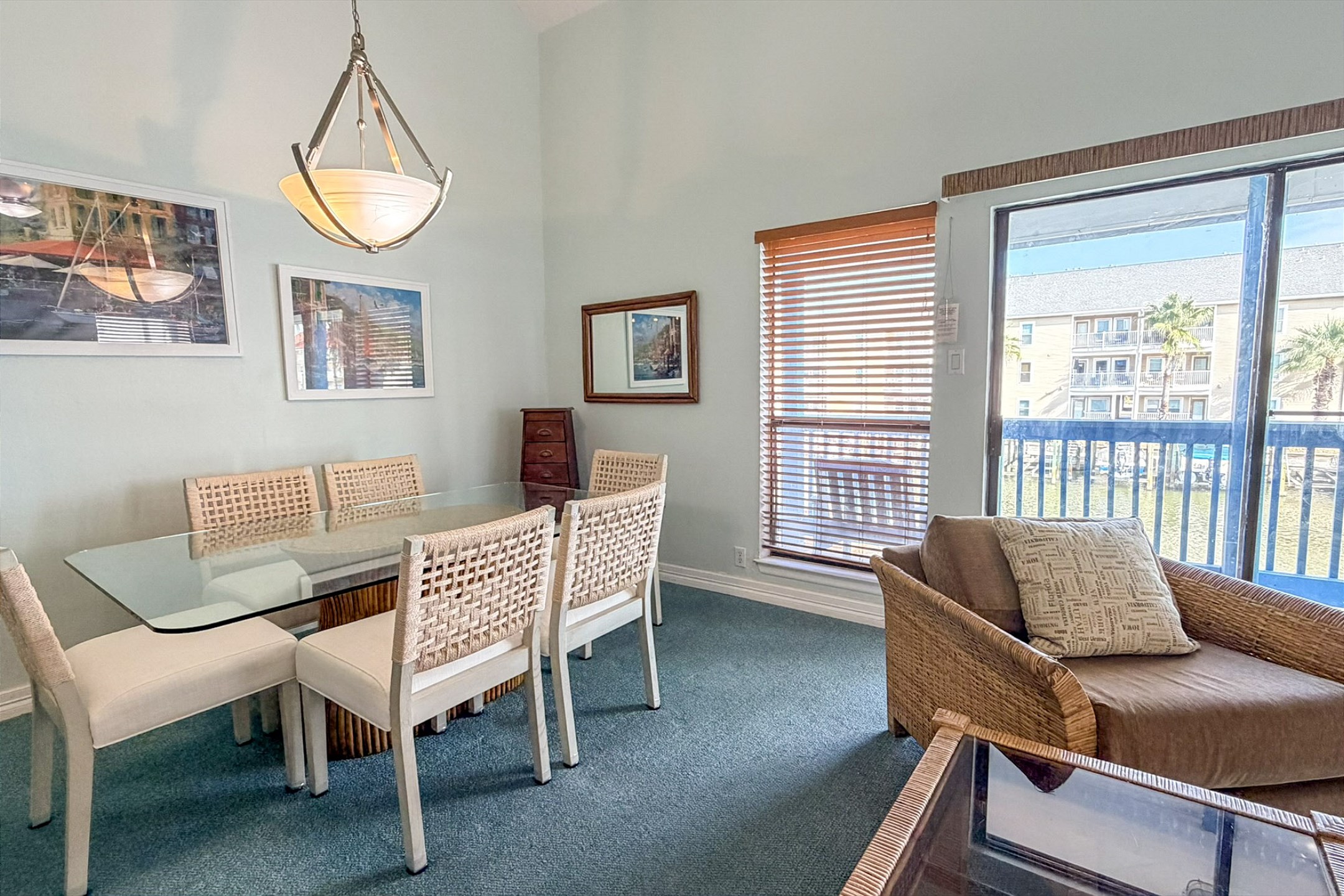 Dining table with new cozy seating for six and large windows allowing the natural light to shine through