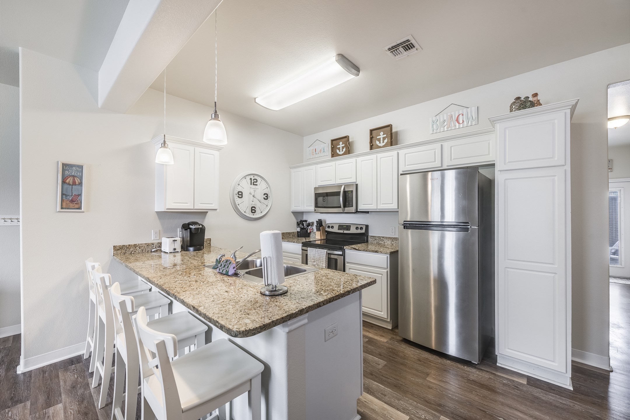 Fully equipped vacation rental kitchen with stainless steel appliances and breakfast bar seating four