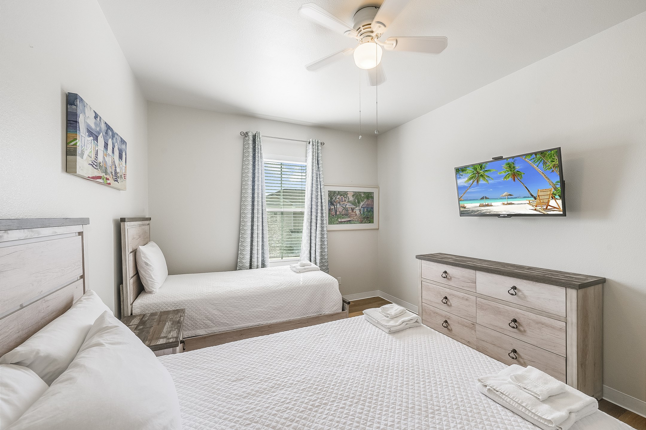 Third bedroom on the second floor with twin and full size bed, along with flat screen TV