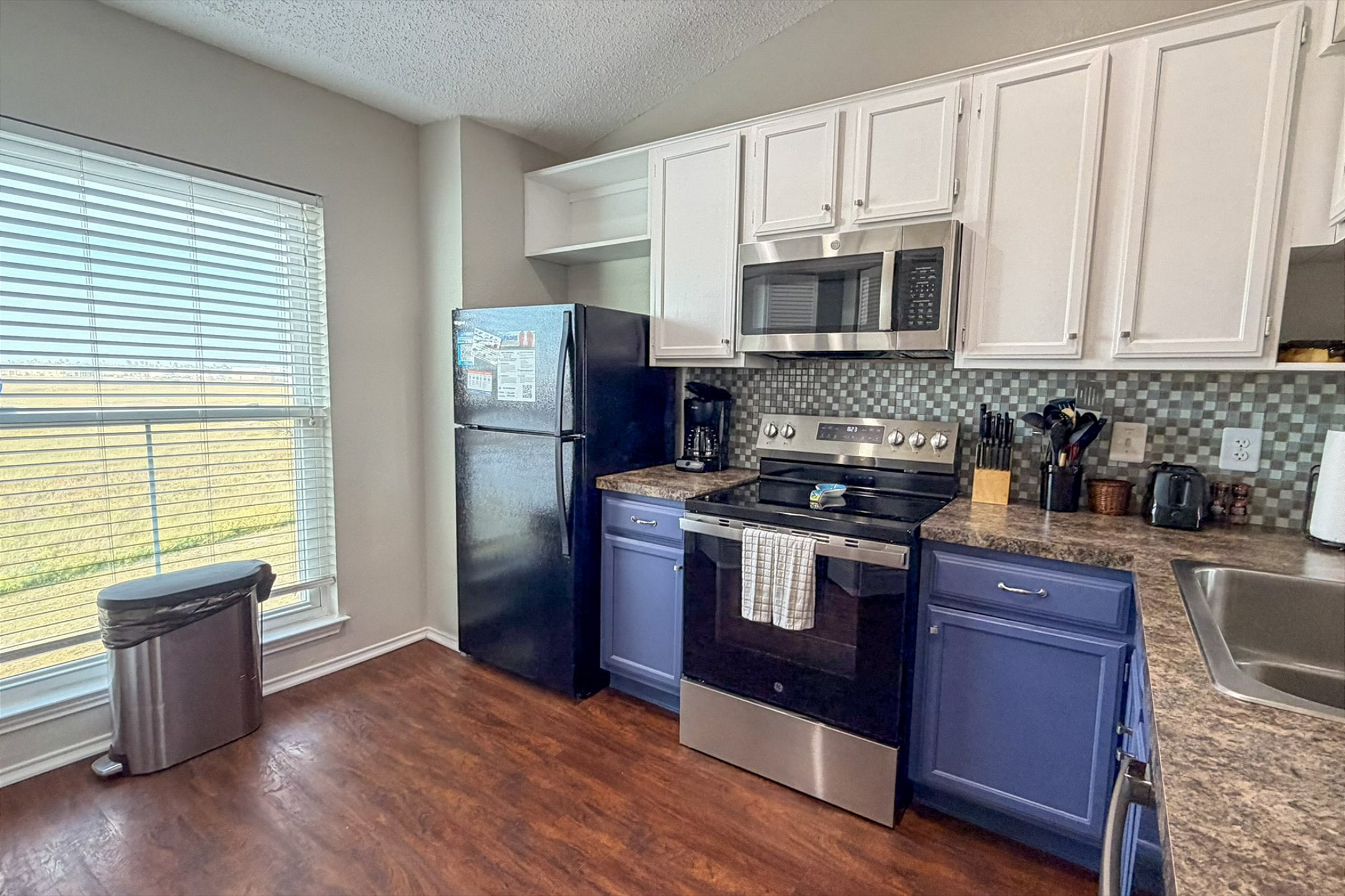 Fully equipped kitchen with new coastal paint - perfect for preparing meals with the family