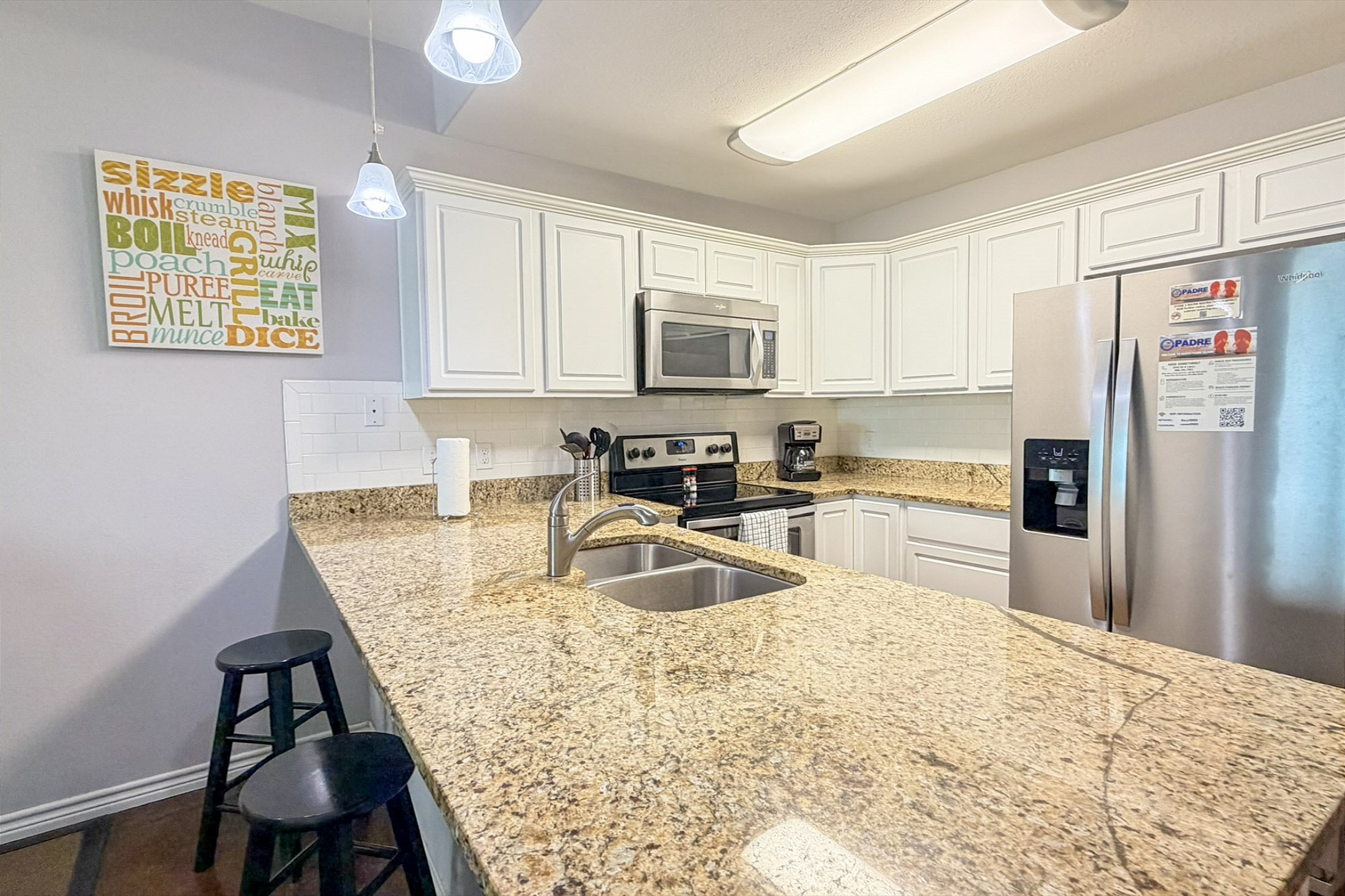 Kitchen area with breakfast bar, stainless steal appliances, plenty of counter space and seating for three at the breakfast bar