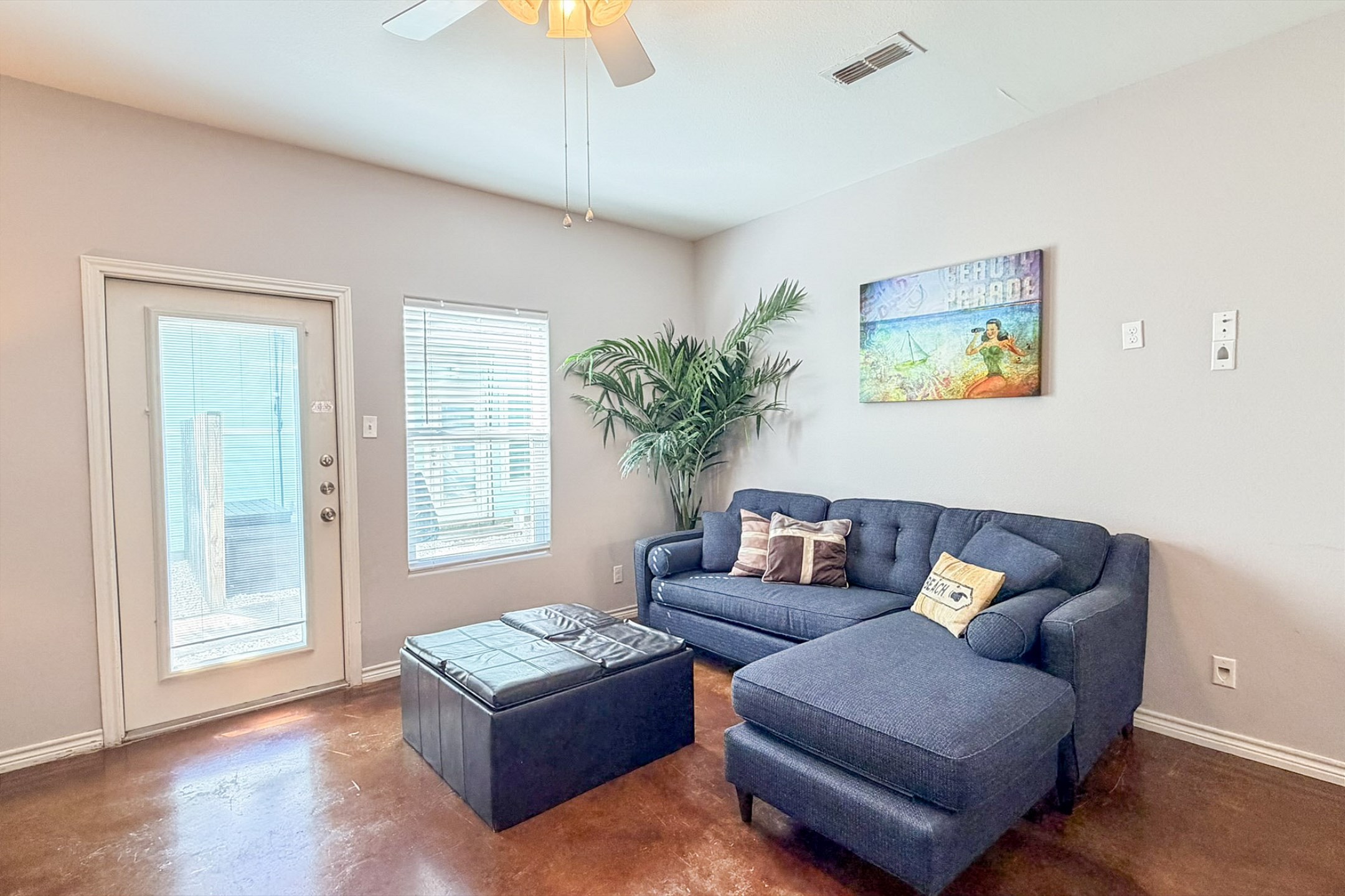 Stylish living room with natural light shining in and cozy couch to relax on 