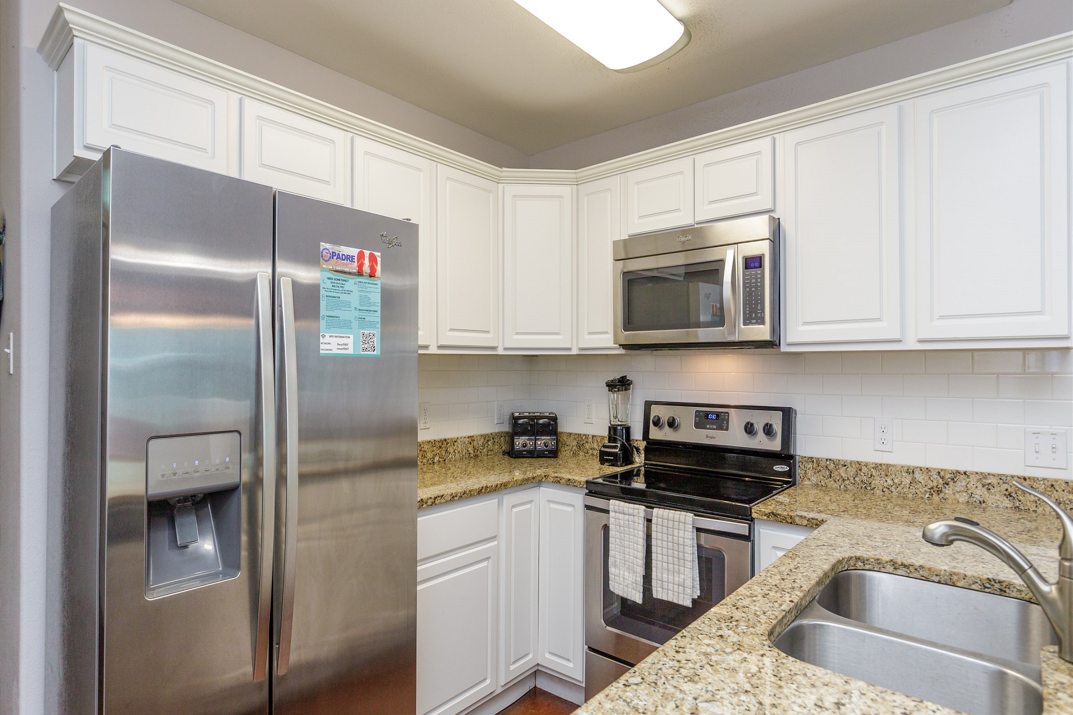 Coffee maker, toaster, cookware, dinnerware, and other kitchen essentials provided in this large kitchen area