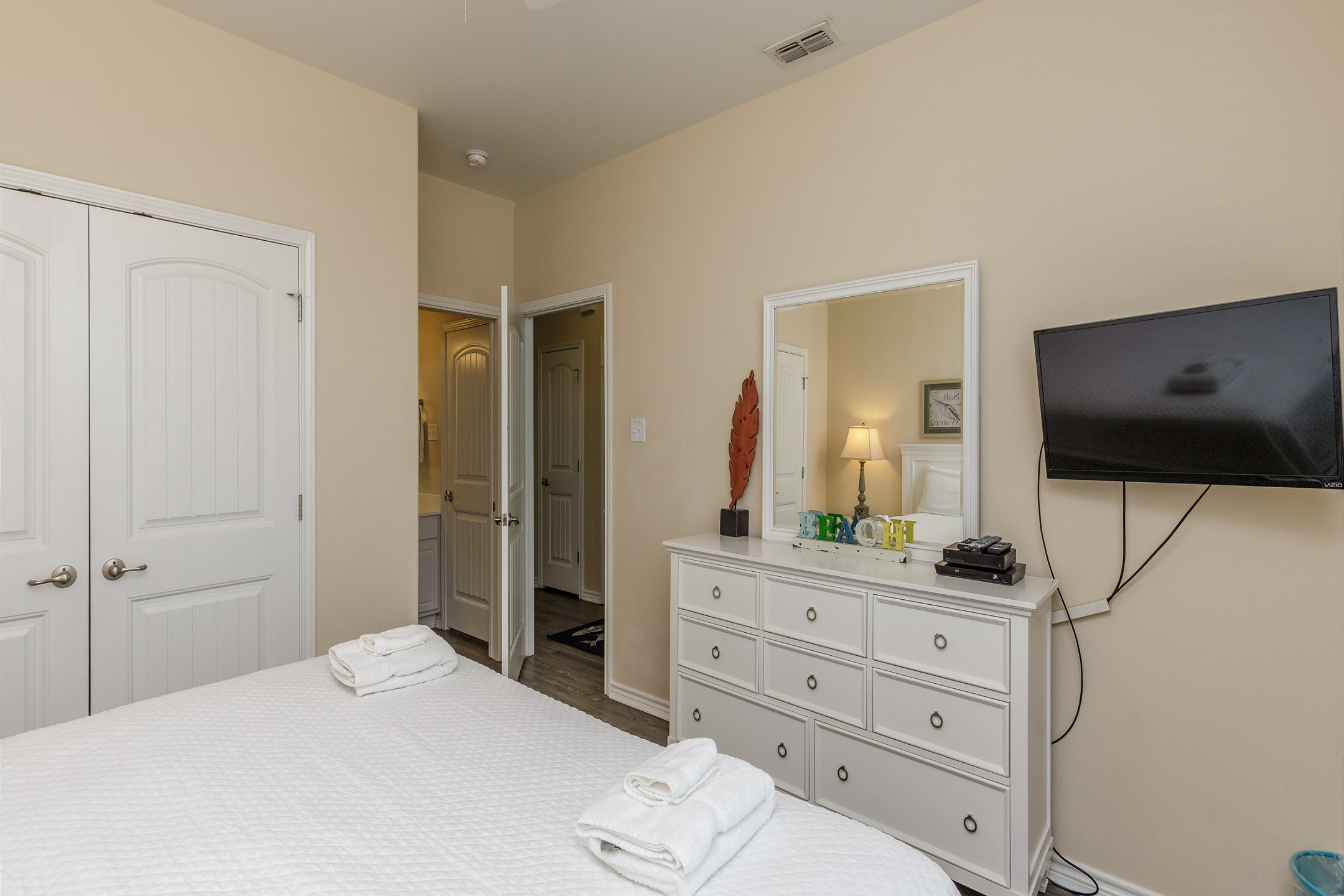Master bedroom on the first floor with a king size bed, flat screen TV, and direct access to the bathroom