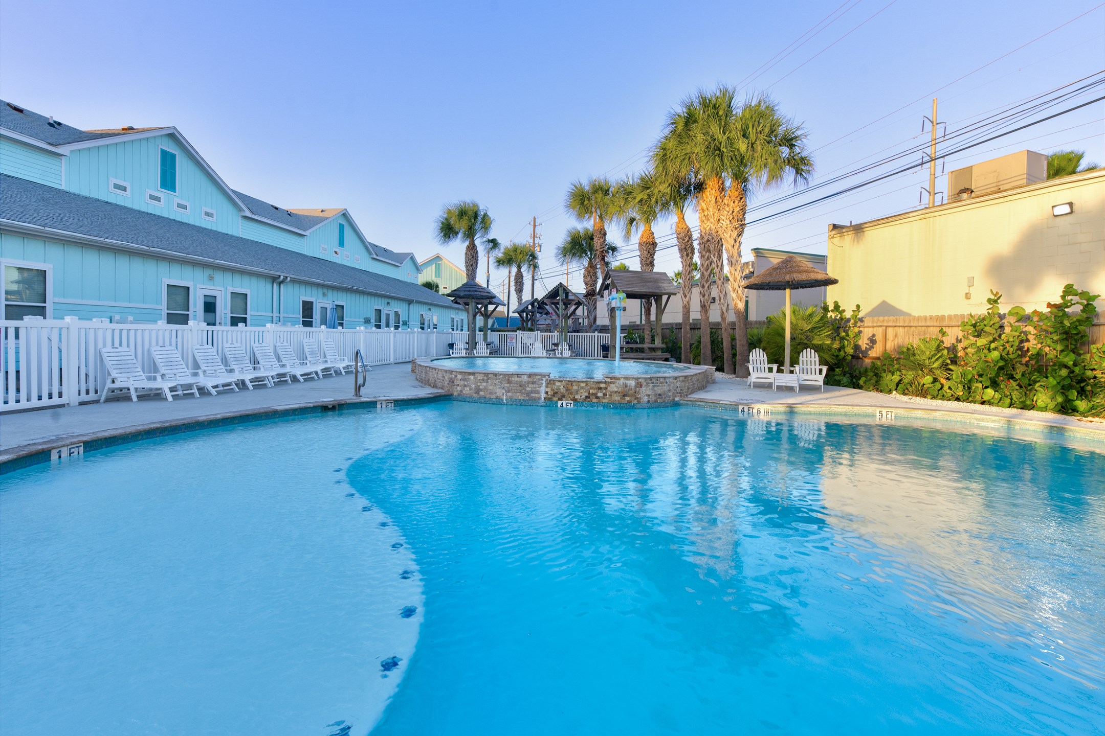 Dive into island vibes at this stunning pool, complete with water features, picnic tables and lounge chairs under Tiki huts