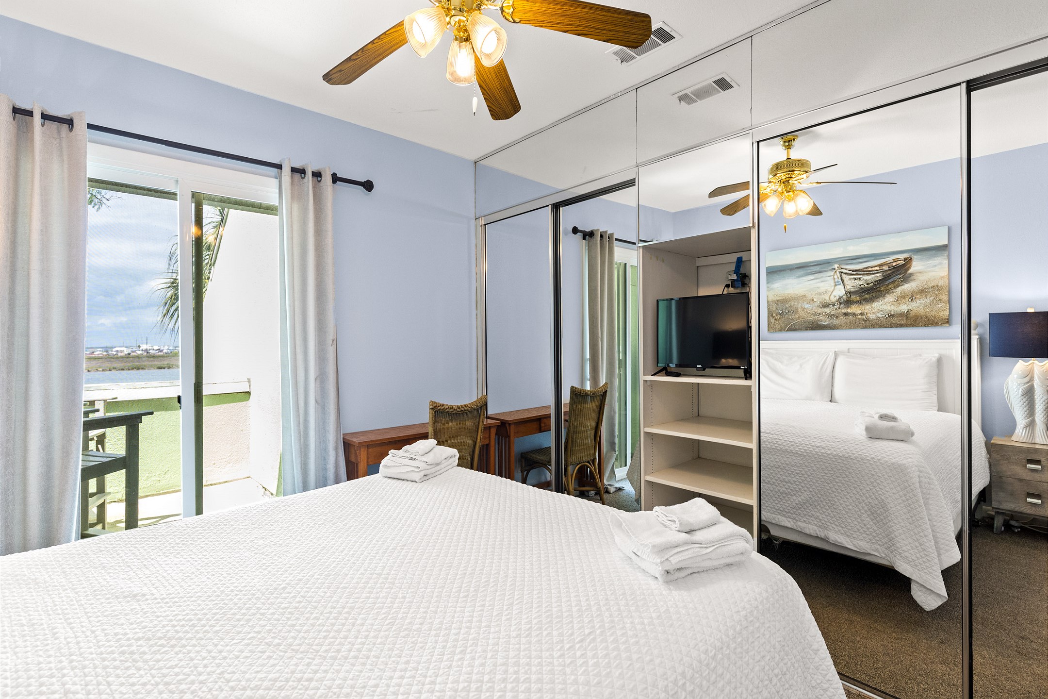 Master bedroom with a king-size bed, private balcony, and en-suite bathroom for ultimate comfort and privacy - along with a flat screen TV to enjoy