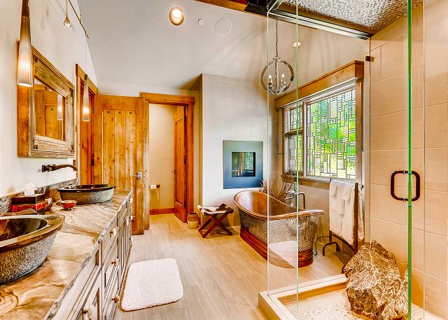 with soaking hydro tub, separate shower, European toilet room, and double sink
