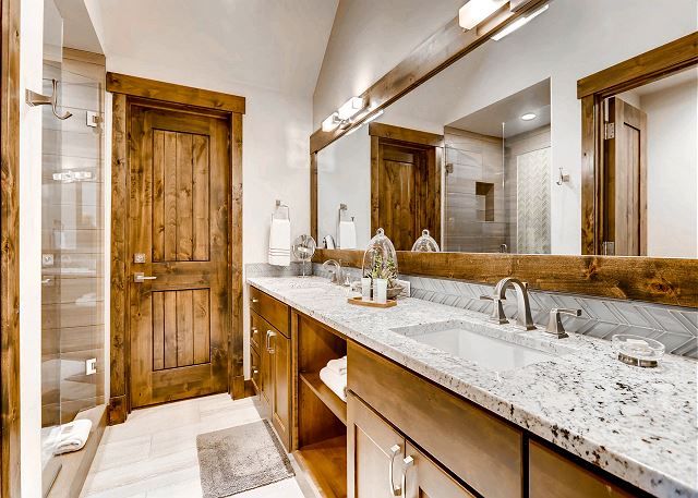 ensuite bathroom with shower and dual sinks