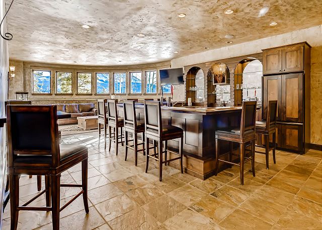features a full bar, full sized refrigerator, 2 TV's, sitting area with sofa and arm chairs and billiards table