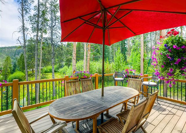Deck in the Summertime with beautiful flowers and outdoor dining space