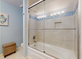 Primary Bathroom with Tiled Tub and Shower Combination