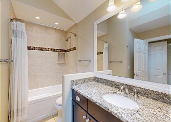 Primary Bathroom with Tiled Tub and Shower Combination