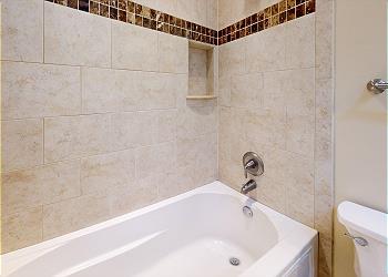 Primary Bathroom with Tiled Tub and Shower Combination