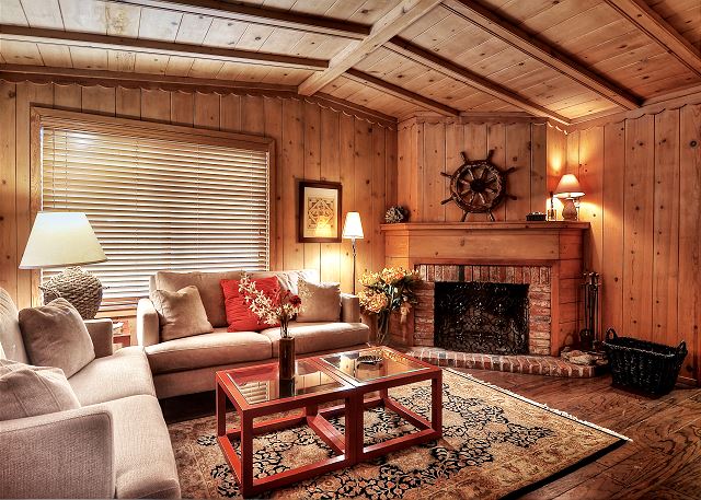 Living room features a high-vaulted ceiling & a wood-burning fir