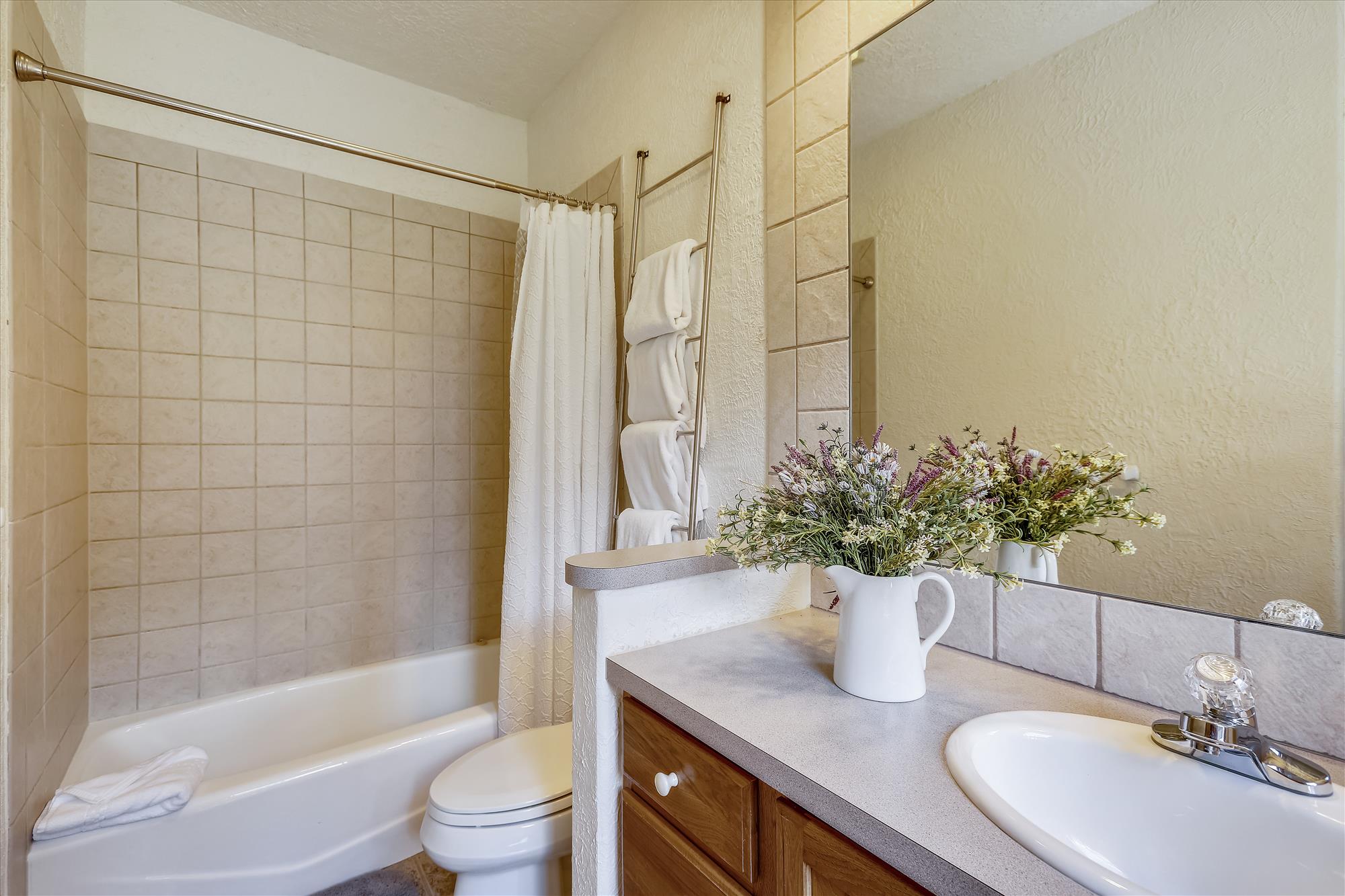 This private bathroom offers a dual tub and shower with lots of natural light - Evergreen Lodge Breckenridge Vacation Rental