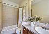 This private bathroom offers a dual tub and shower with lots of natural light - Evergreen Lodge Breckenridge Vacation Rental 