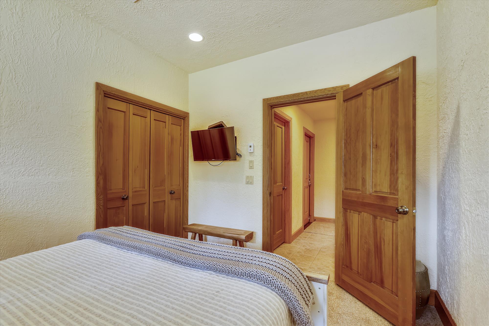 Queen bedroom with closet space and TV - Evergreen Lodge Breckenridge Vacation Rental