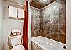 Jetted tub and shower combo in shared lower level bathroom - 4 O’Clock Lodge D26 Breckenridge Vacation Rental 