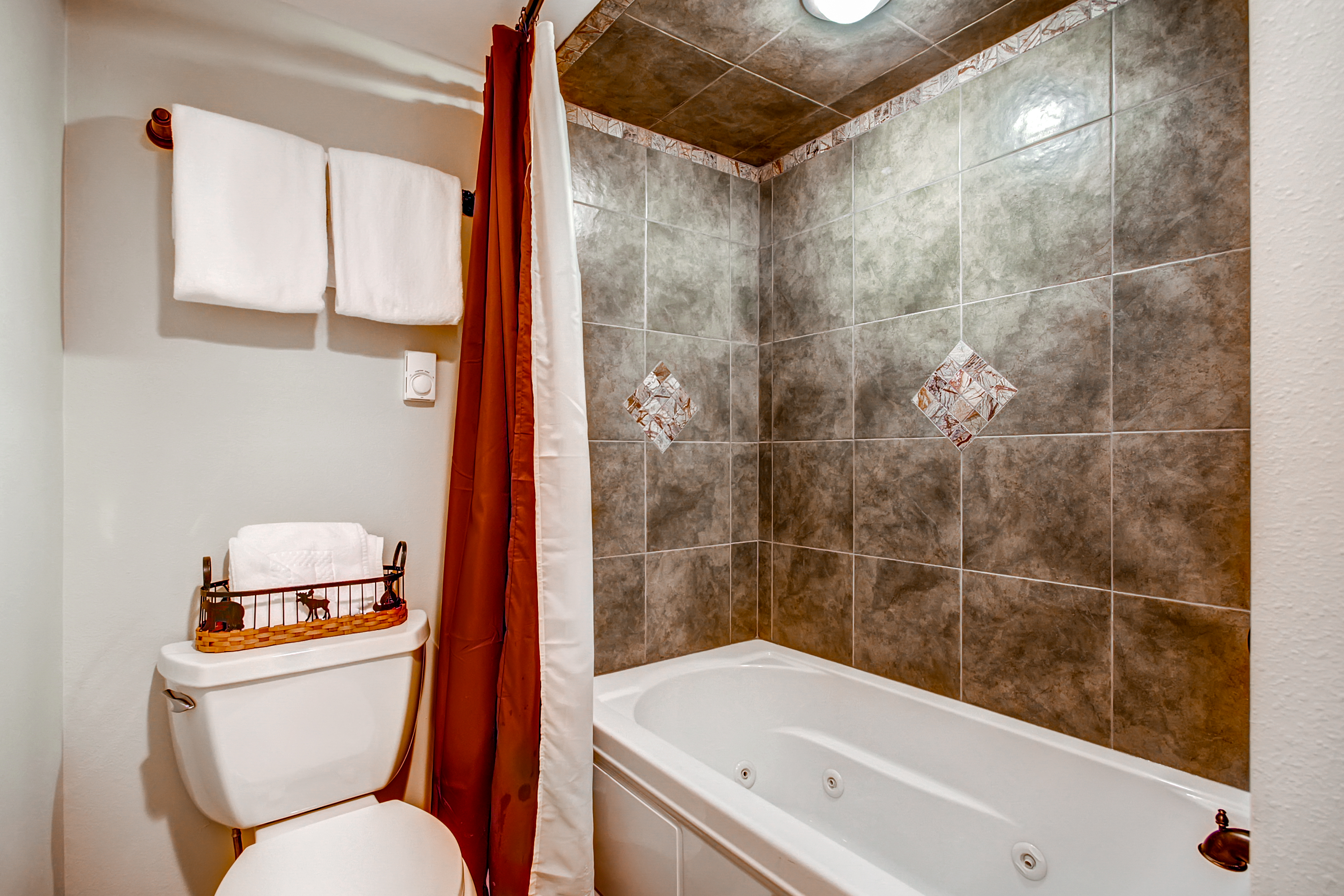 Jetted tub and shower combo in shared lower level bathroom - 4 O’Clock Lodge D26 Breckenridge Vacation Rental