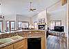 View of living room from kitchen that has cookware, utensils, cups and dishes. - Charter Ridge 60 Breckenridge Vacation Rental 