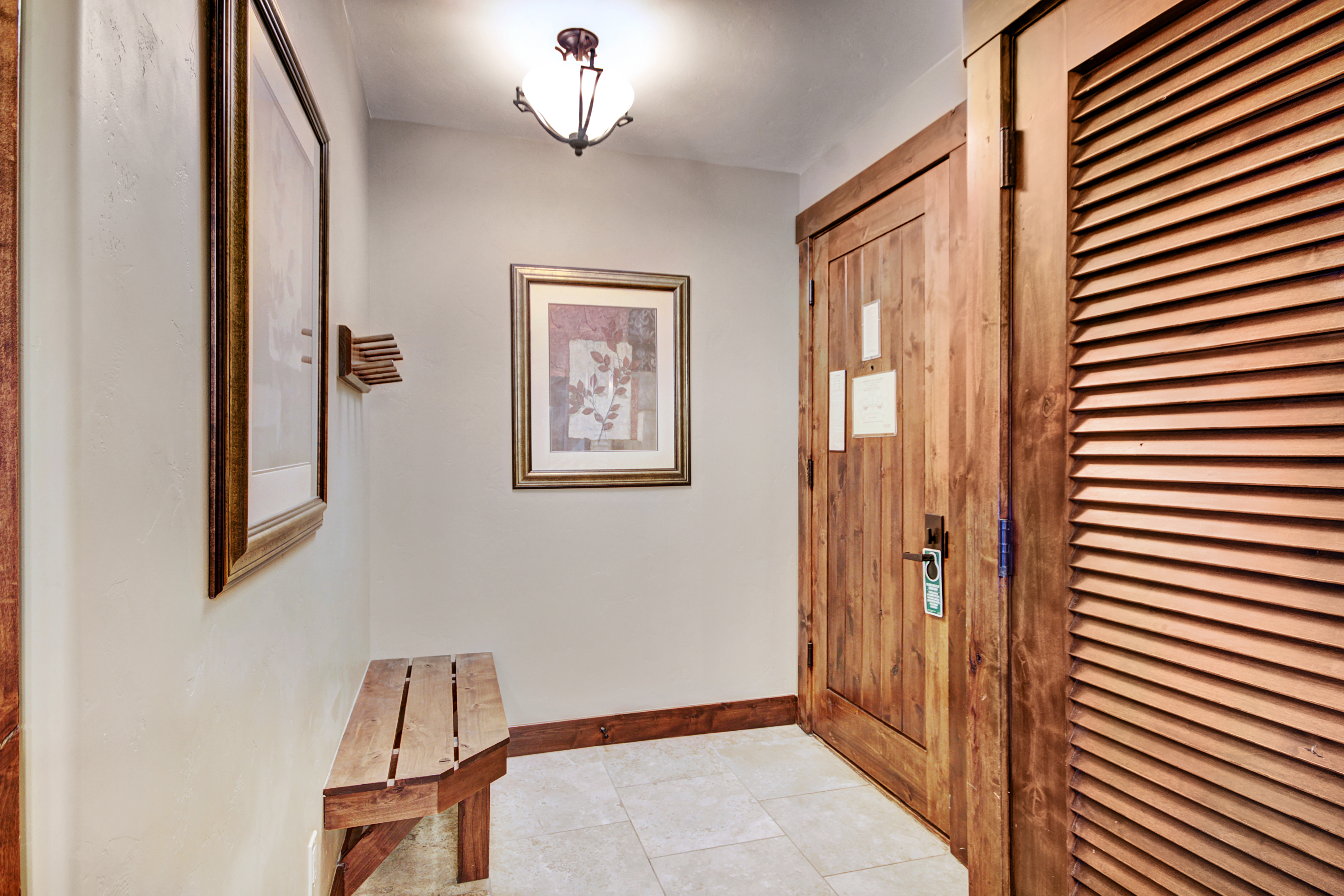Front entryway with a bench and coat rack.