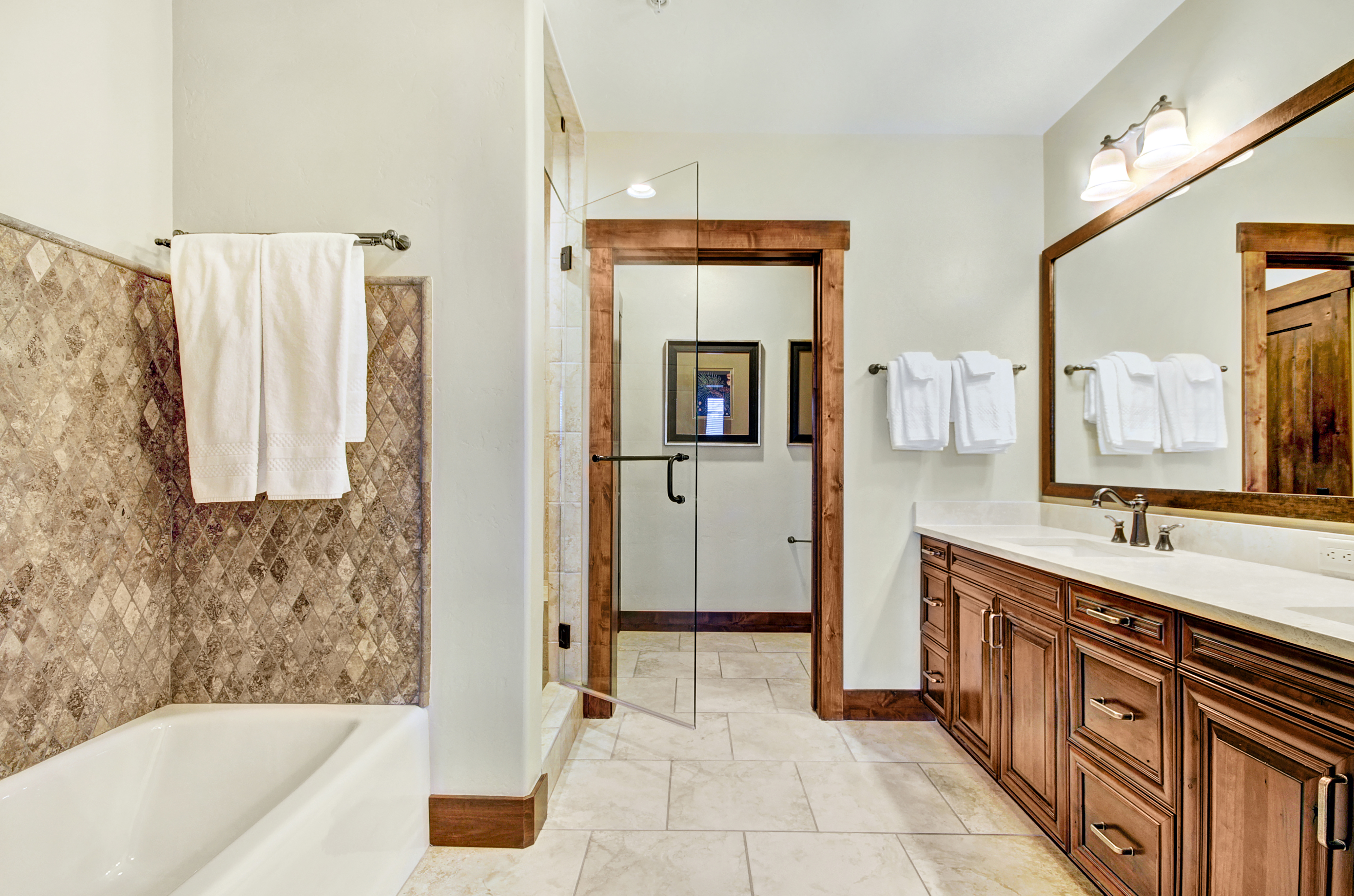 Master bathroom with dual vanity, walk in shower, and soaking tub.