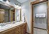 Double sinks in master bathroom with view into bedroom