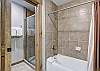 Master bathroom includes both a walk-in shower and combination bathtub/shower