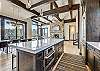 Kitchen island view with four spaces of bar seating, overlooking the living and dining areas - Barton Creek Vista Breckenridge Vacation Rental 