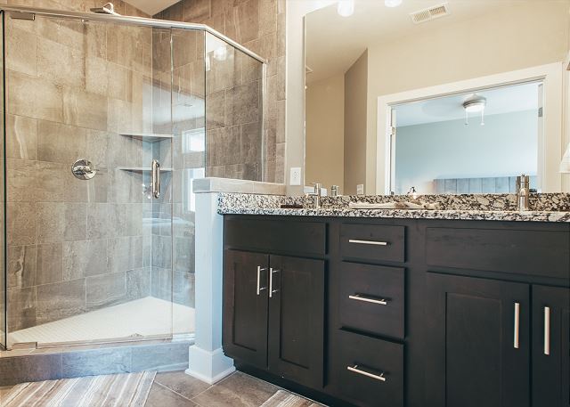 Double Vanity and Large, Glass Enclosed Shower with Floor to Ceiling Tile