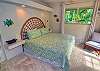  A King Bed in the Second Bedroom with a french doors leading to a tropical lanai.